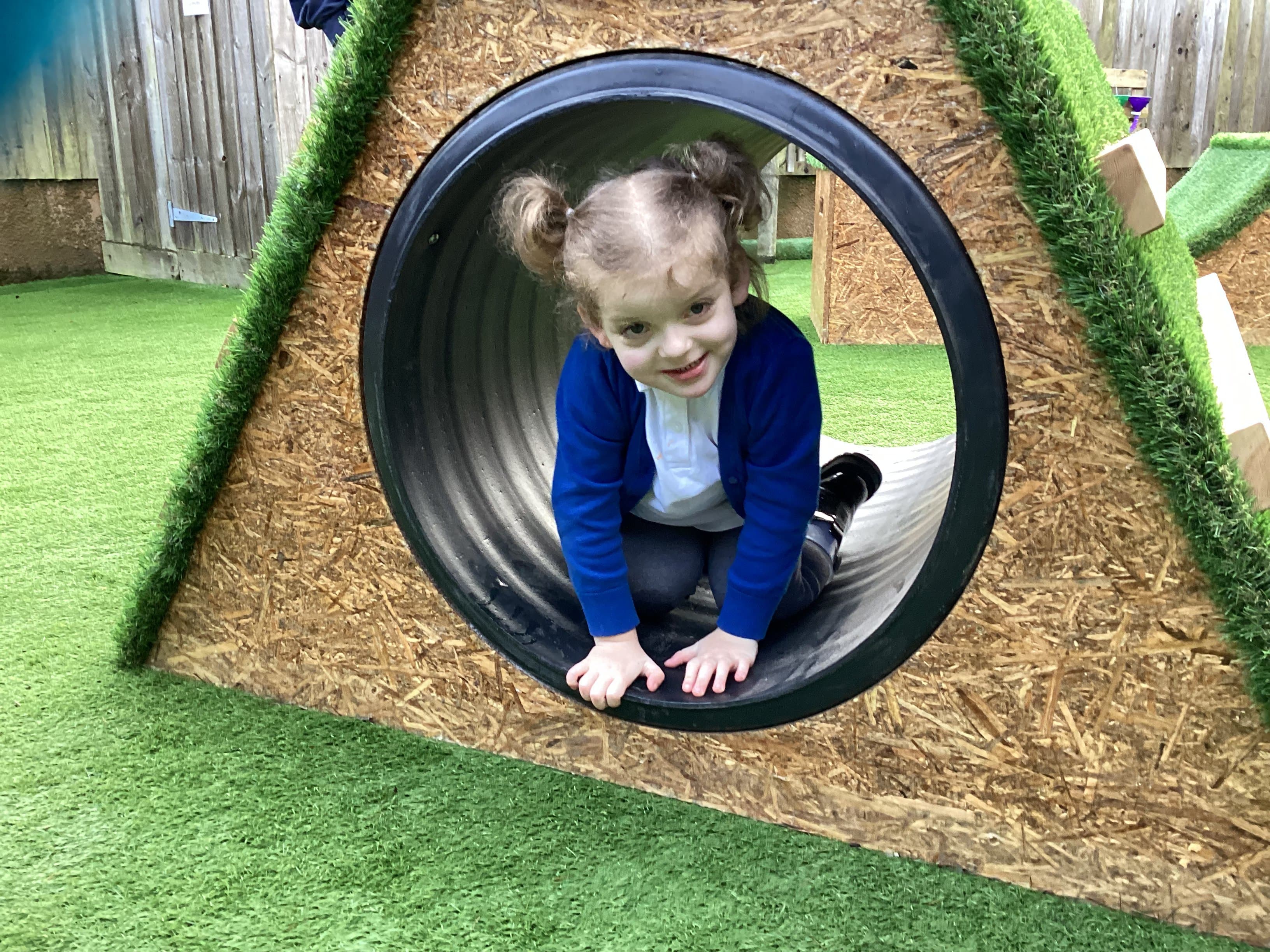 Girl crawling through the play tunnel